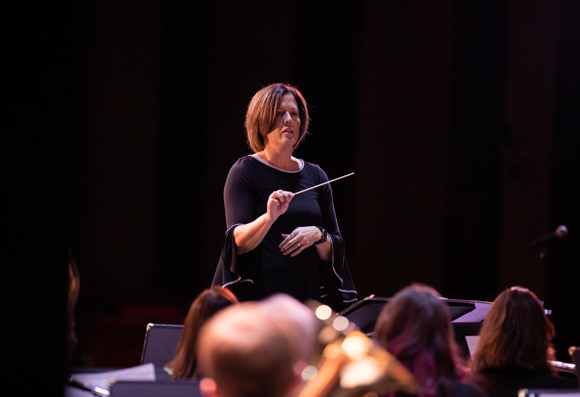 woman directing a group of musicians