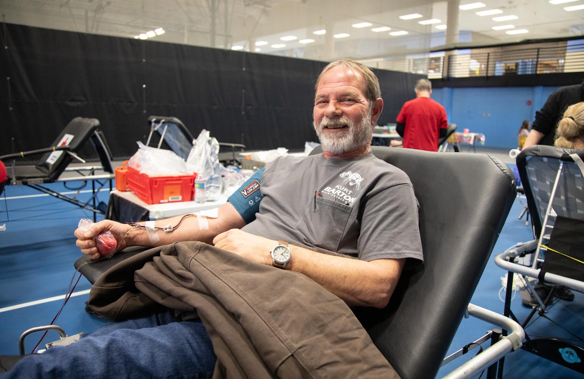 man smiles while donating blood