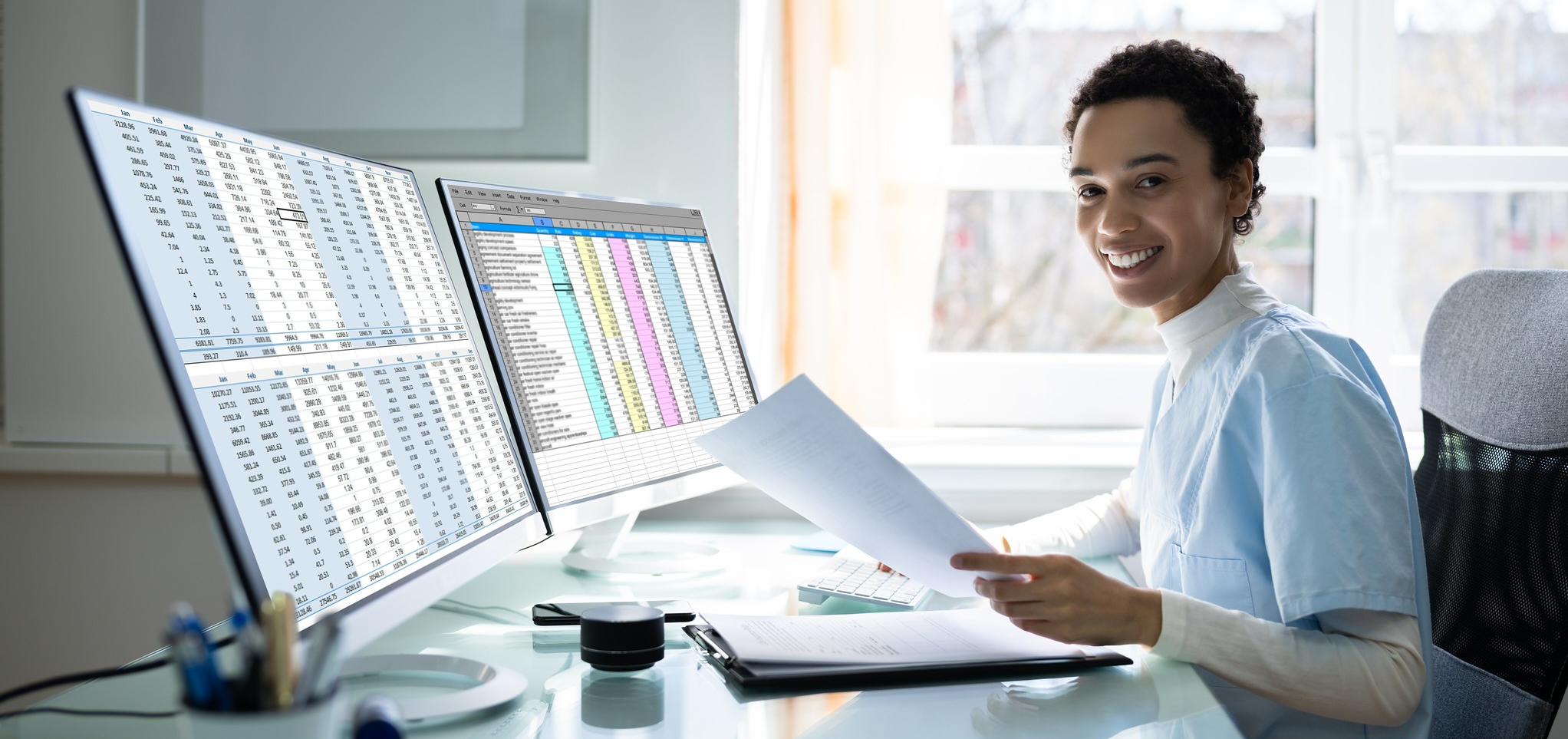 Medical Coding personnel looks at papers and computer