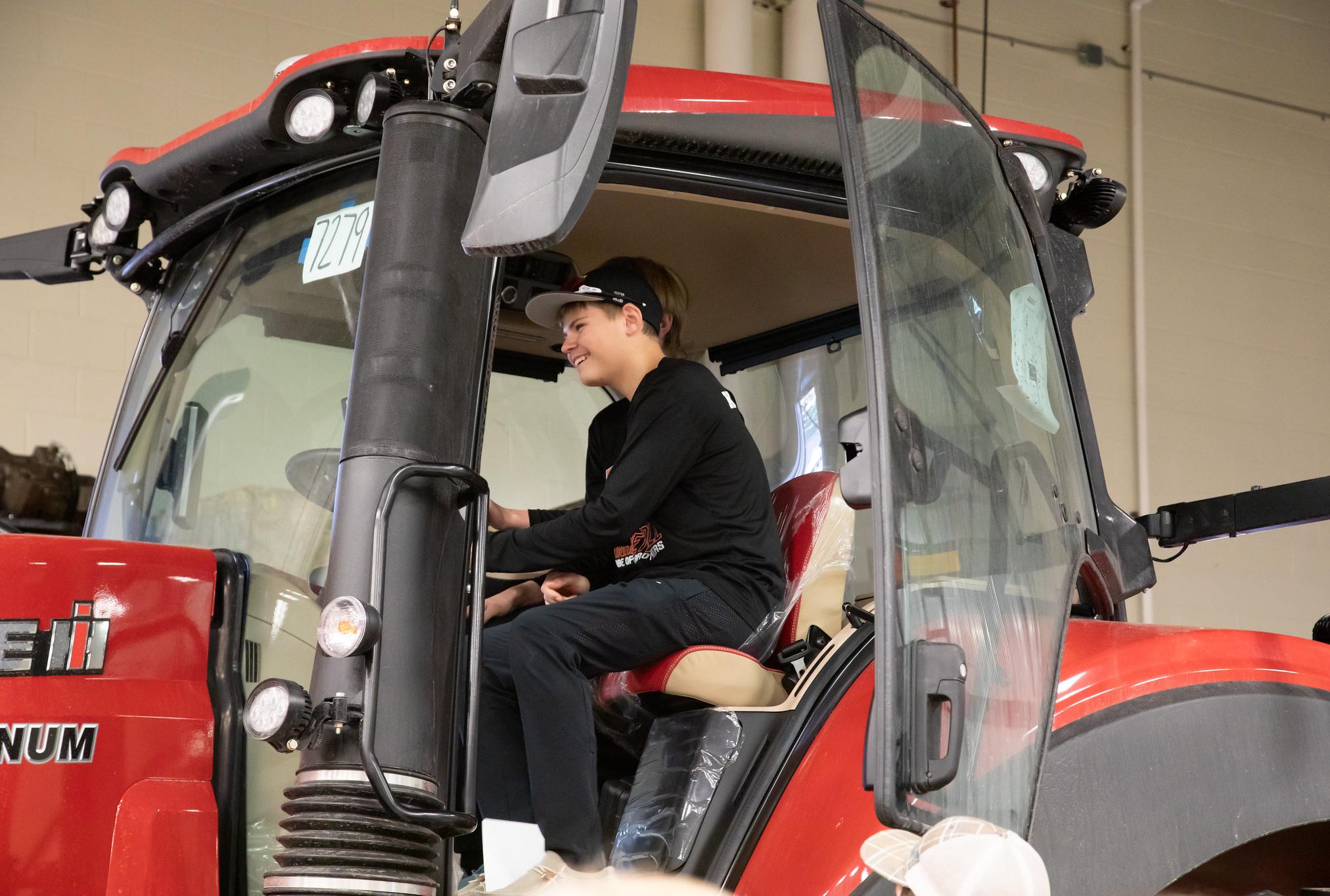 kid on a tractor with a big smile on his face