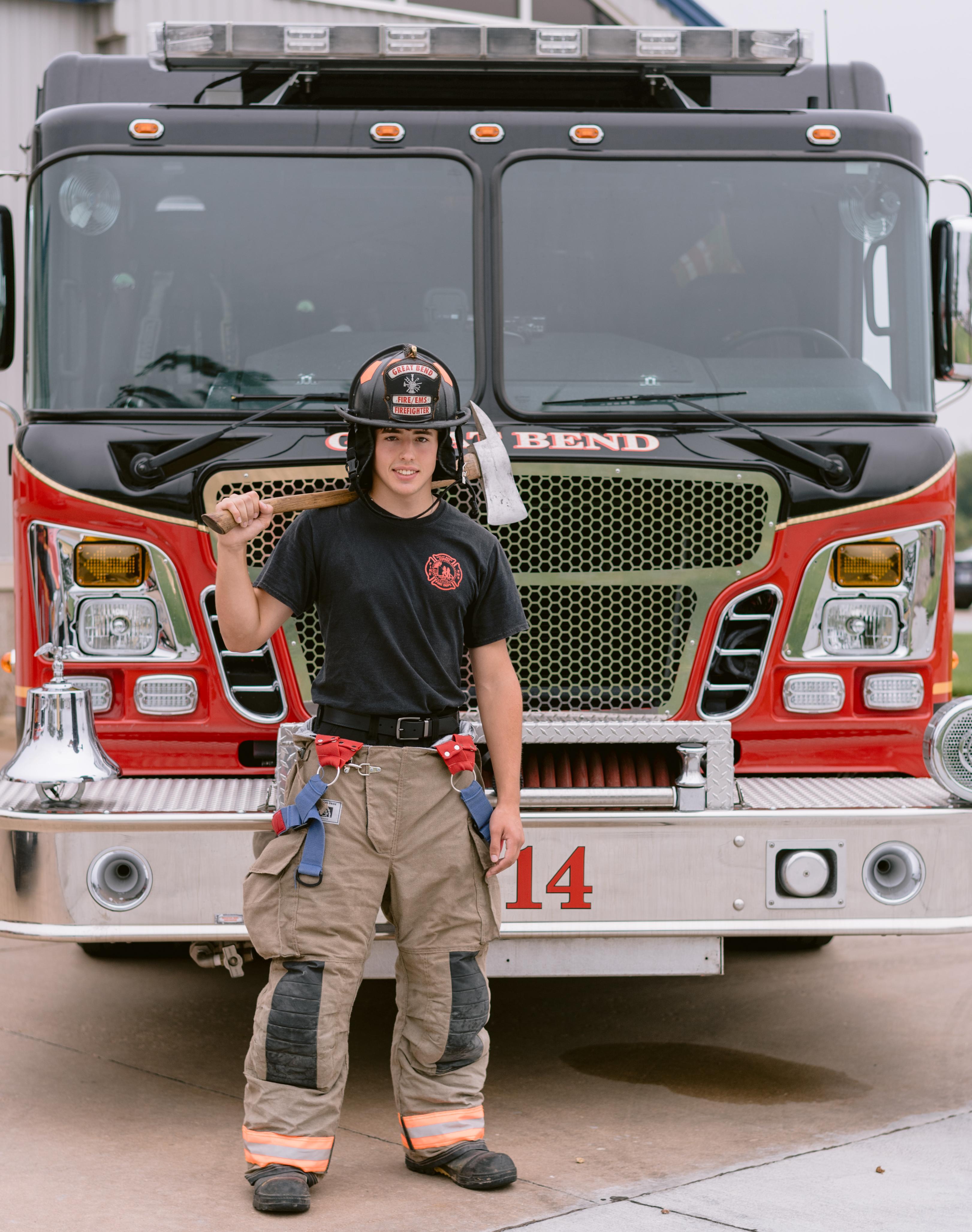 young fireman in front of a firetruck