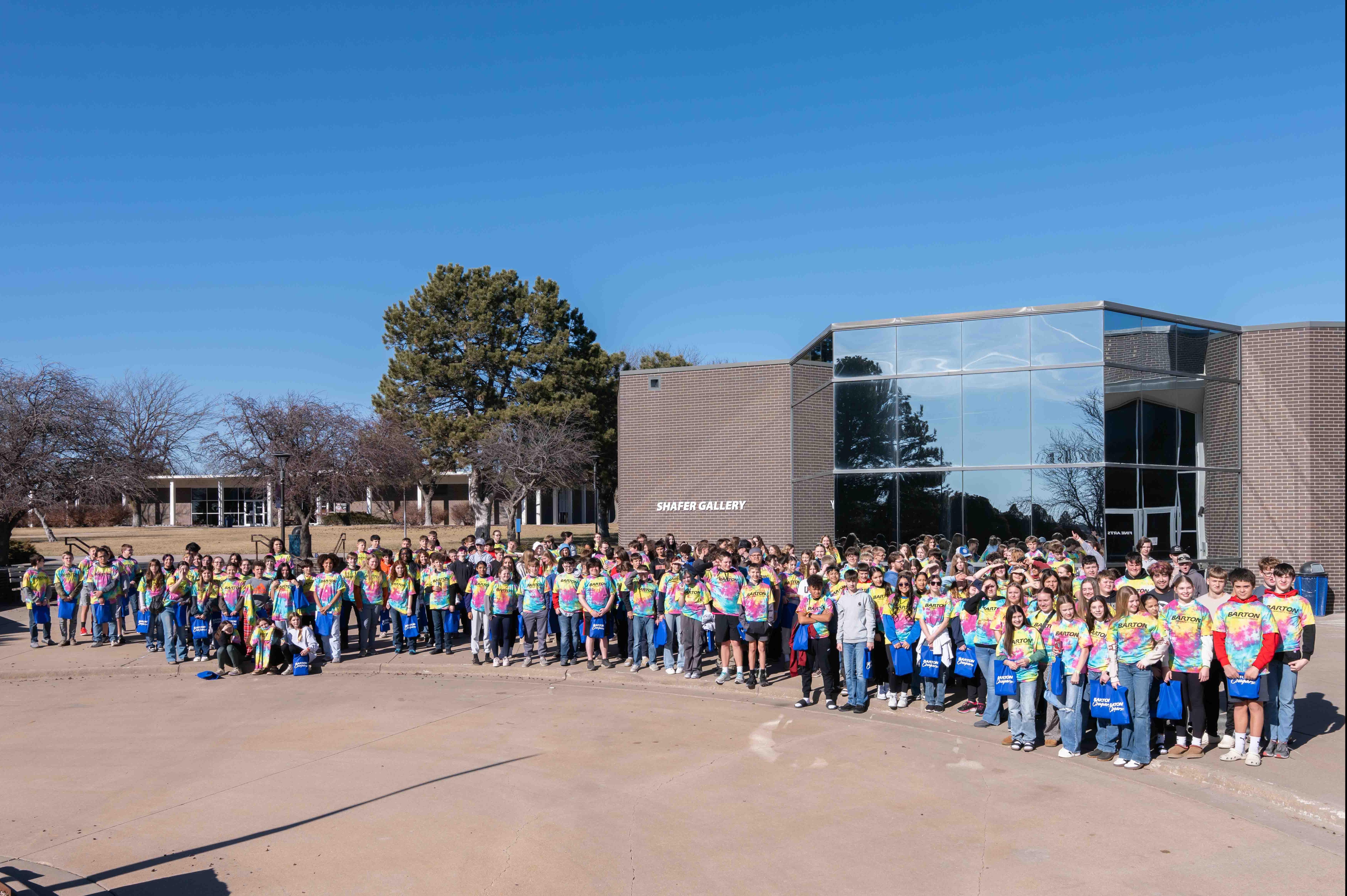 students standing in front of a building with a bunch of shiny windows