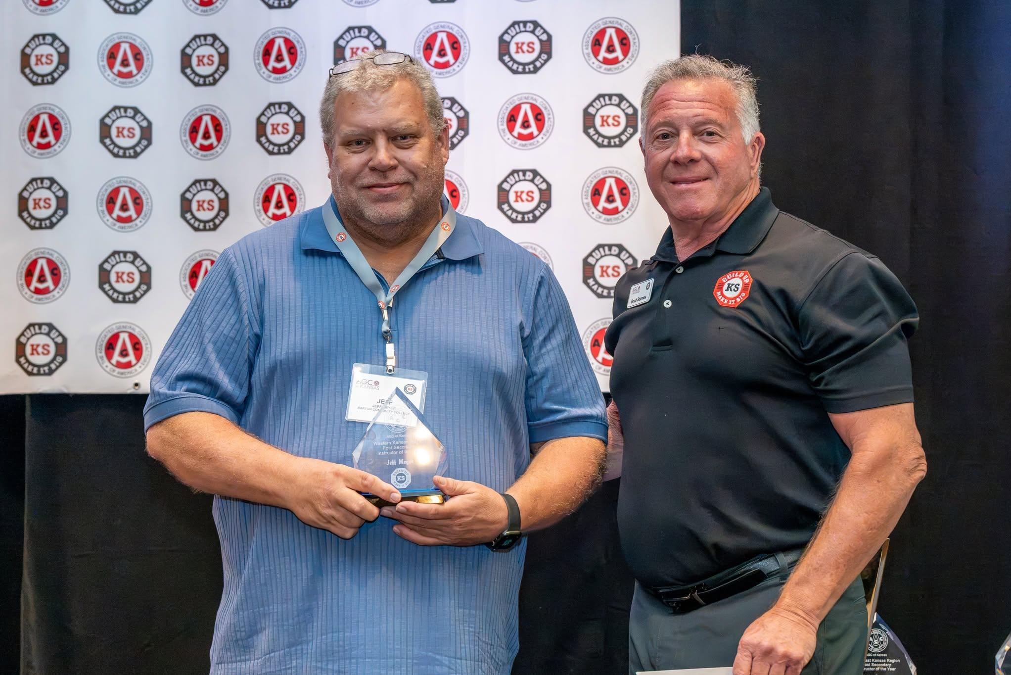 man smiling with award with presenter