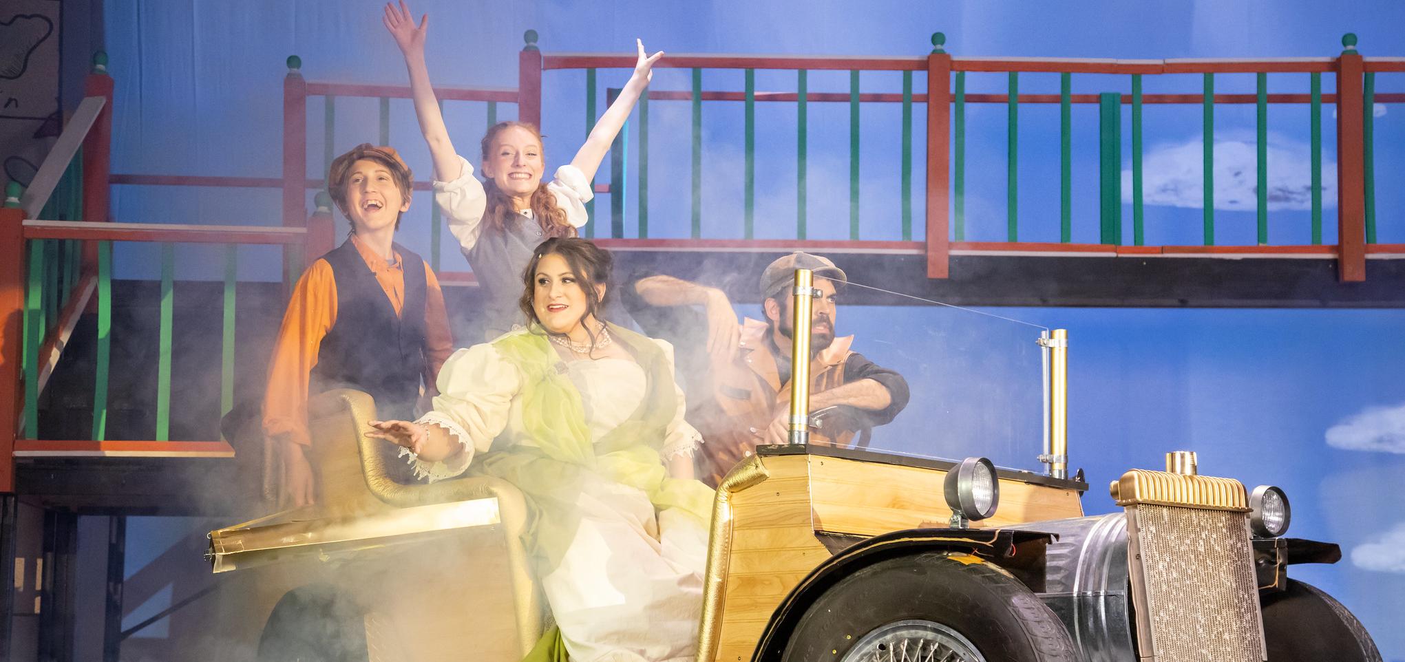 Actors smile in the theatre production of Chitty Chitty Bang Bang