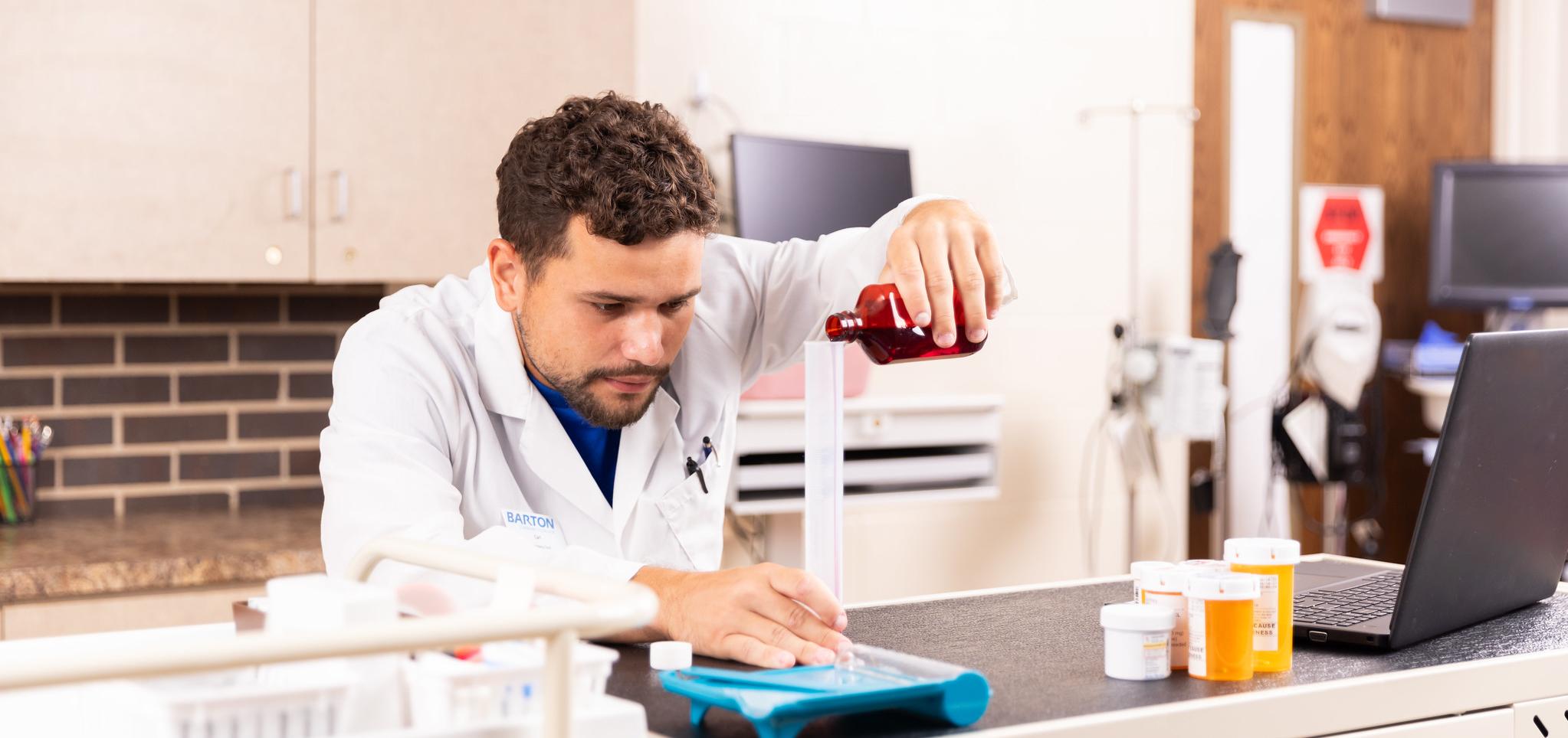 Pharmacy technician measures medicine